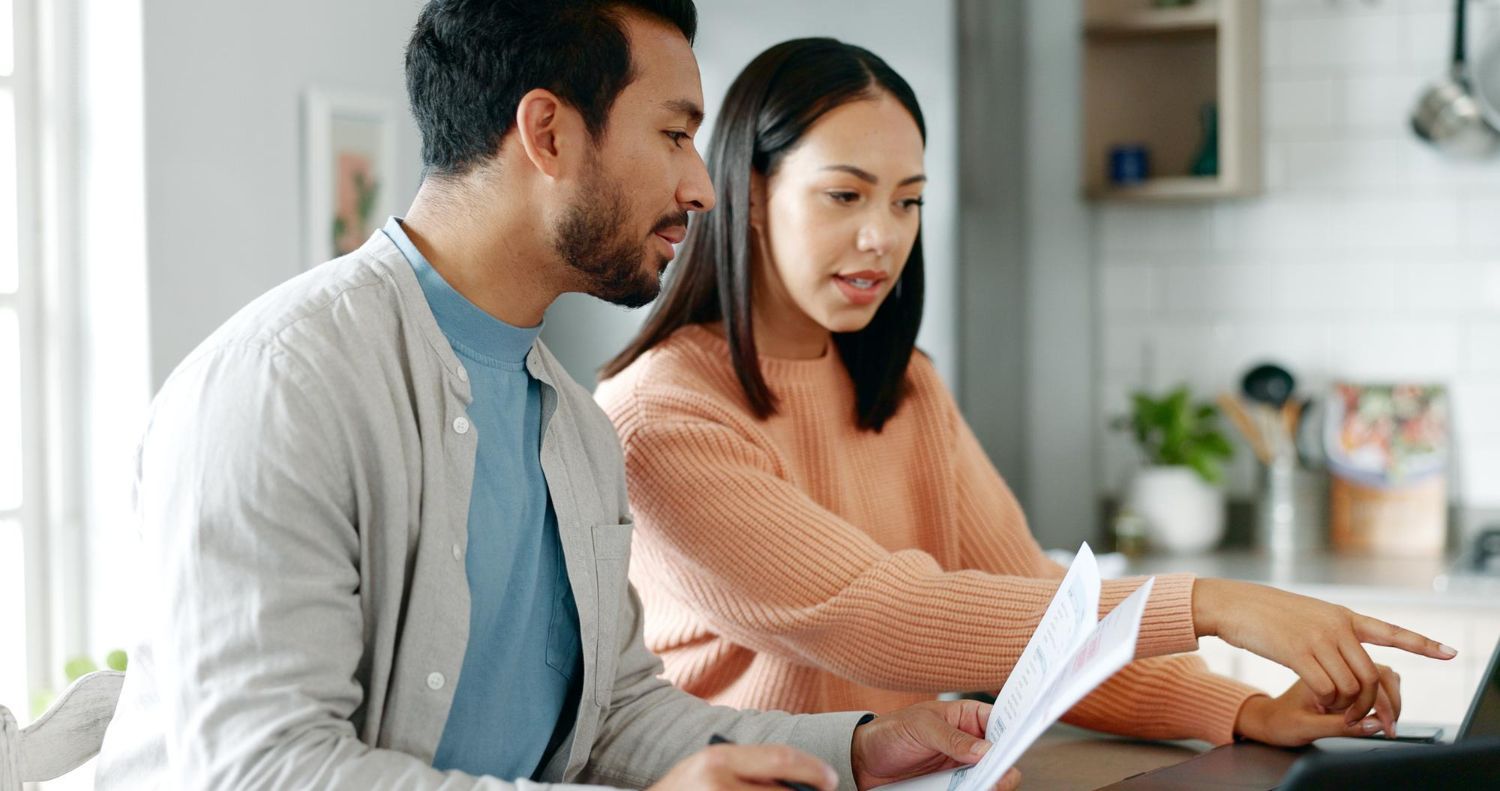 Financial advisor explaining documents to a couple at a table.