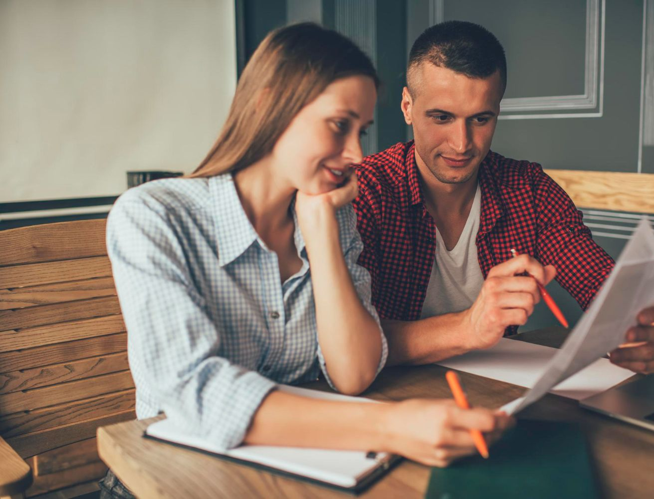 Financial advisor explaining documents to a couple at a table.