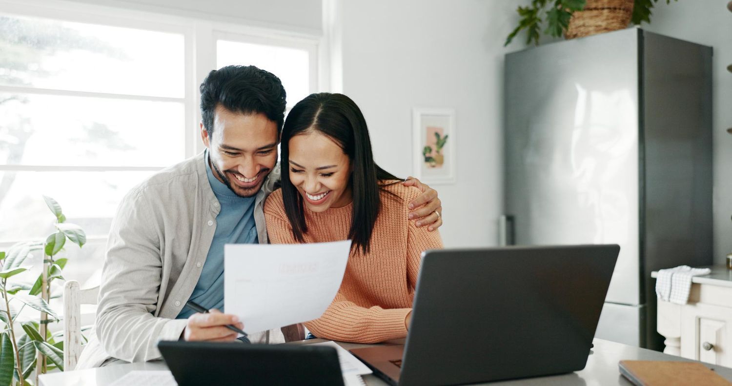 Financial advisor explaining documents to a couple at a table.