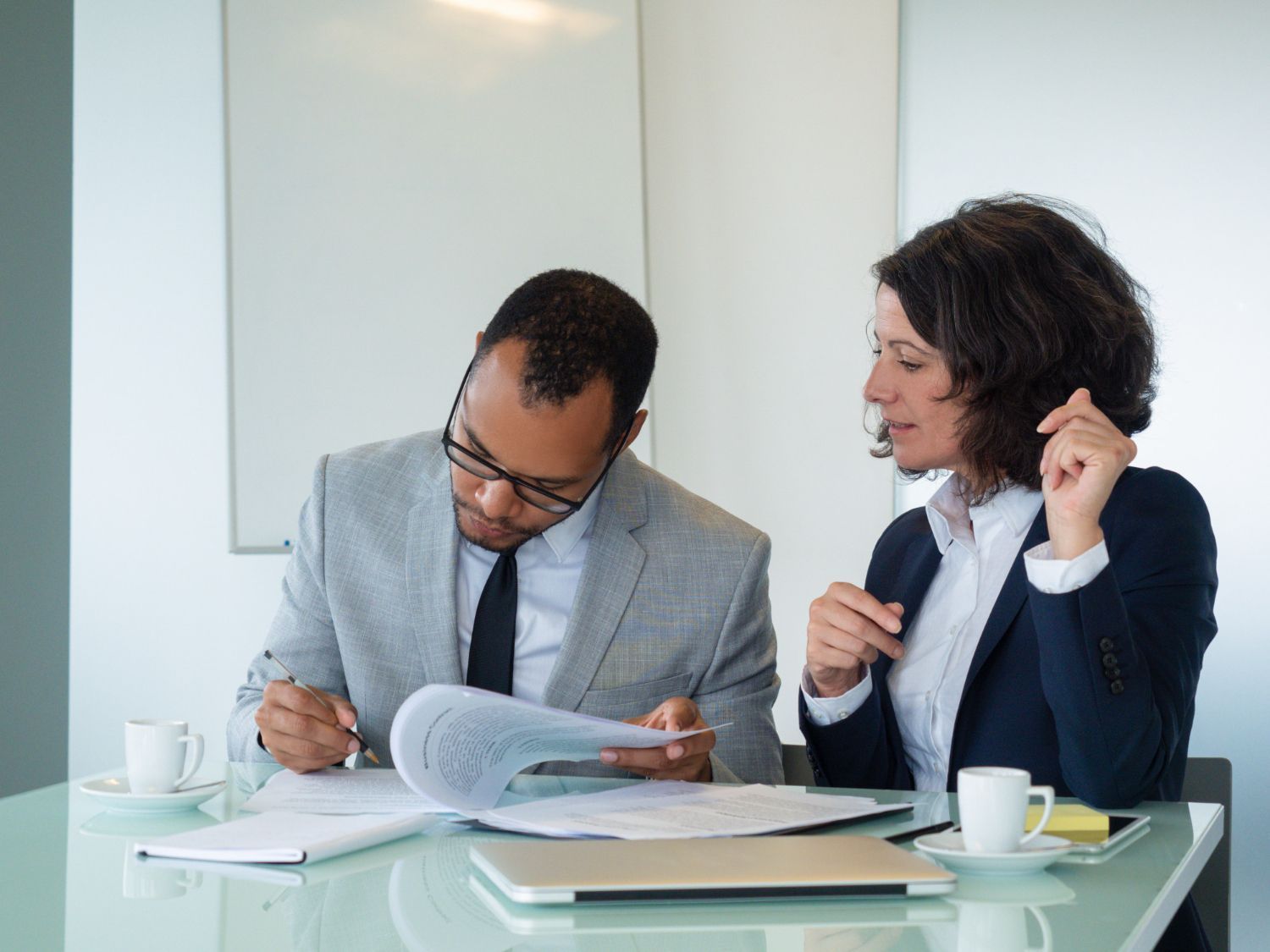 Financial advisor explaining documents to a couple at a table.