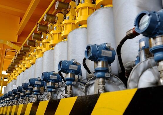 A row of blue and white cylinders are lined up in a warehouse