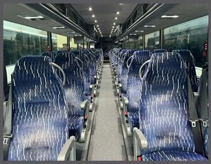 The inside of a bus with a lot of blue seats