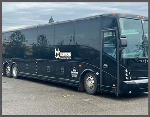 A black bus is parked on the side of the road.