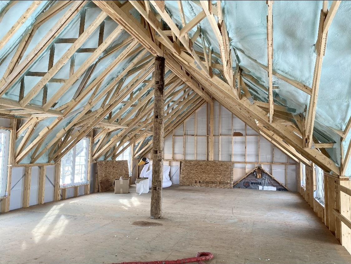une grande pièce avec beaucoup de poutres en bois et isolation au plafond.