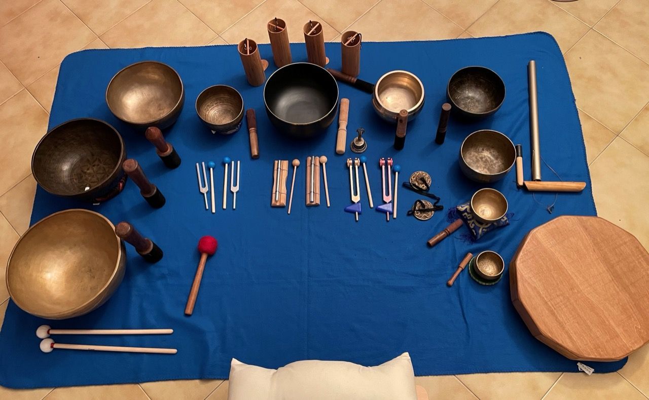 Vari utensili da cucina in metallo e legno disposti su un telo blu.