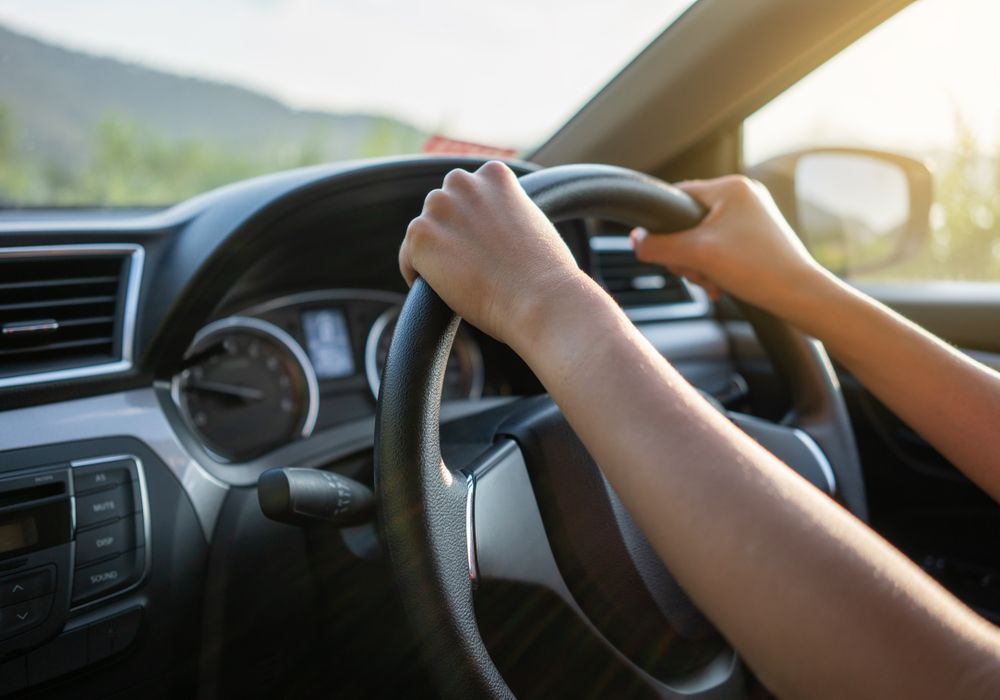 Hands on a Steering Wheel While Driving a Car in Sunlight — Van Diemen's Automotive & Electrical Repairs In Bellerive, TAS