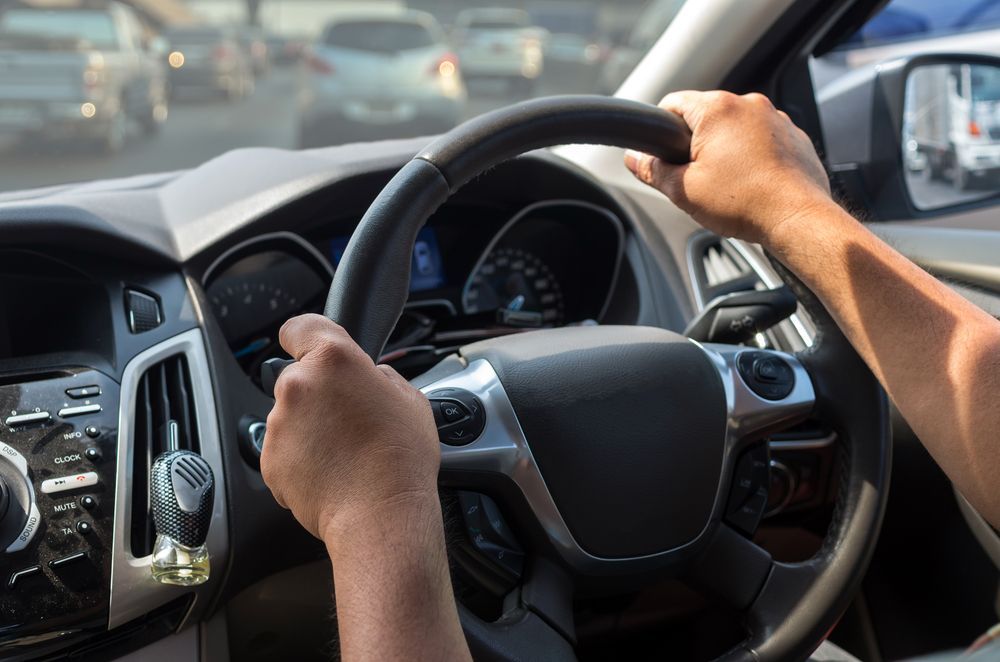 Driver’s Hands Gripping a Steering Wheel Inside a Car on a Road — Van Diemen's Automotive & Electrical Repairs In Bellerive, TAS