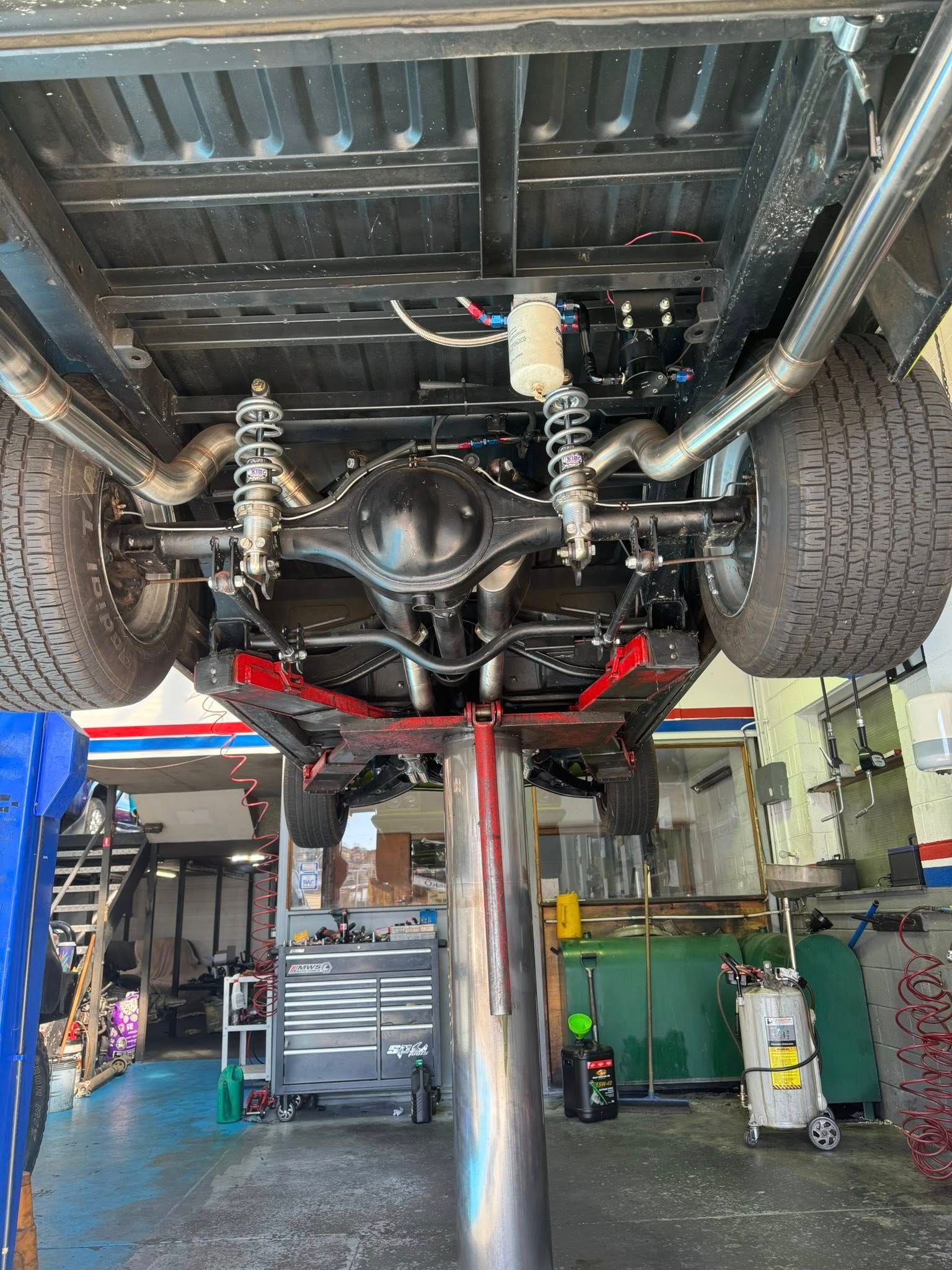 Undercarriage of a Lifted Truck on a Shop Lift, Showing Suspension, Axle, and Exhaust — Van Diemen's Automotive & Electrical Repairs In Bellerive, TAS