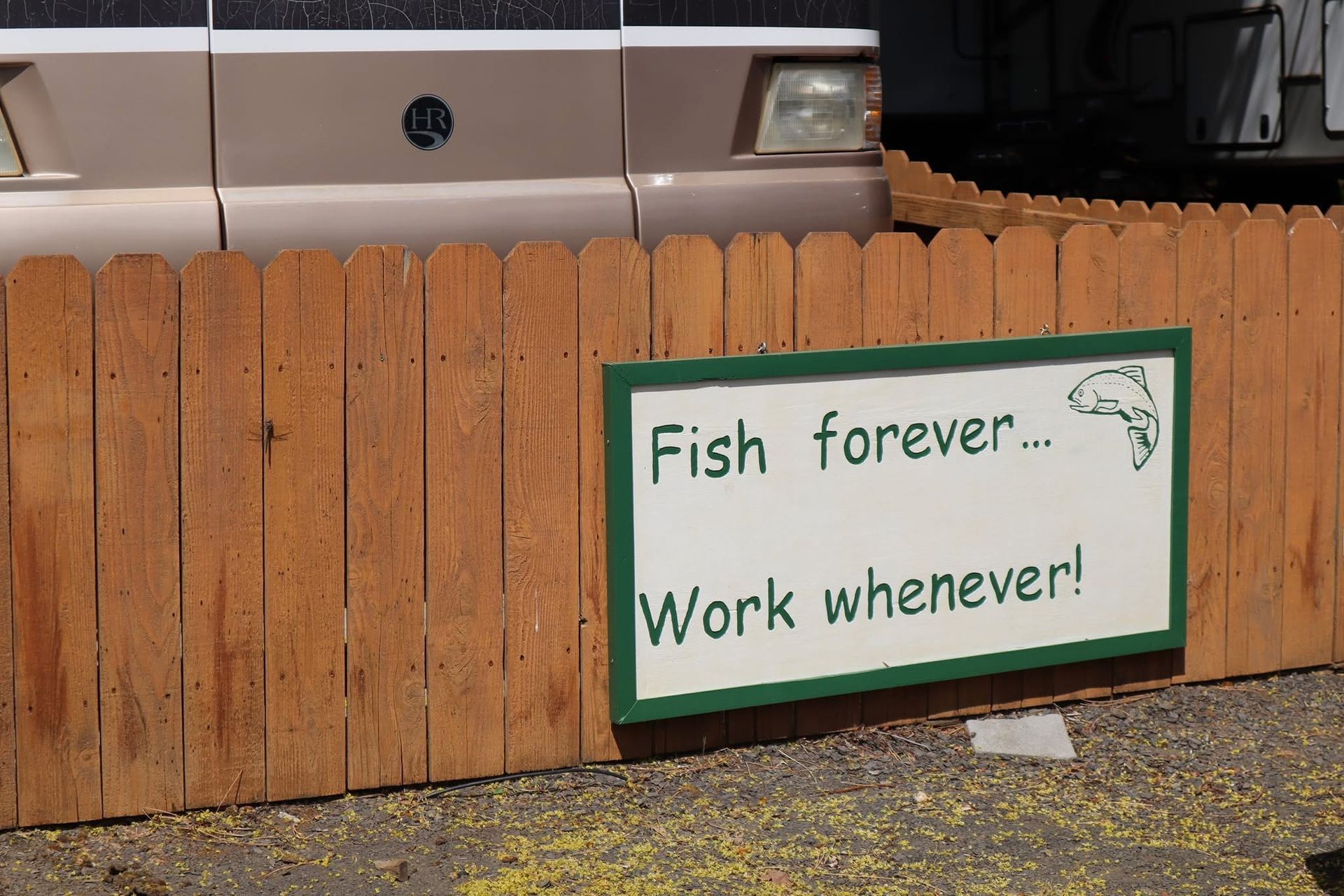 Brown wooden fence with a sign that reads, 