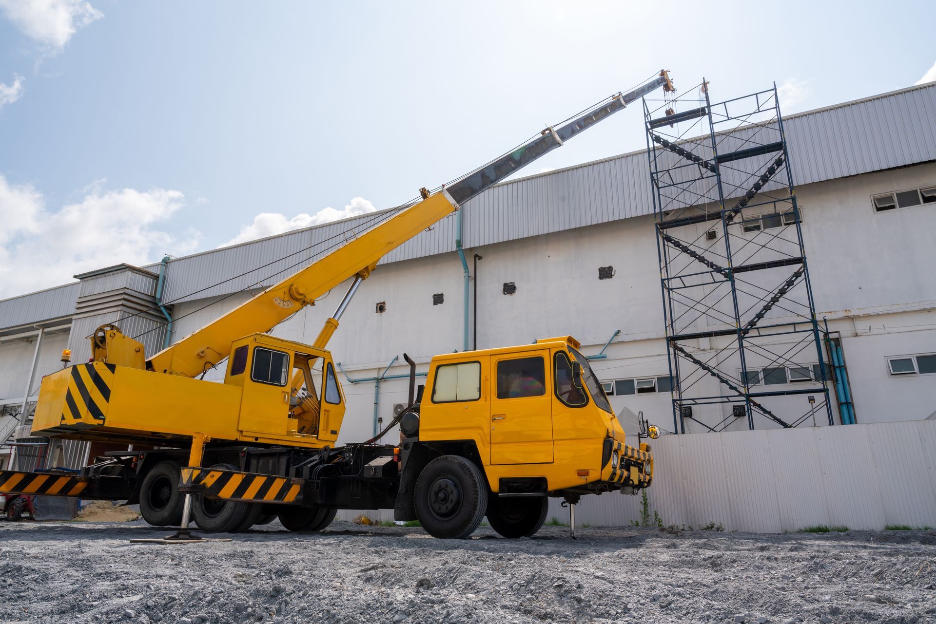 Crane service lifting materials at an industrial construction site. Crane service lifting materials at an industrial construction site.