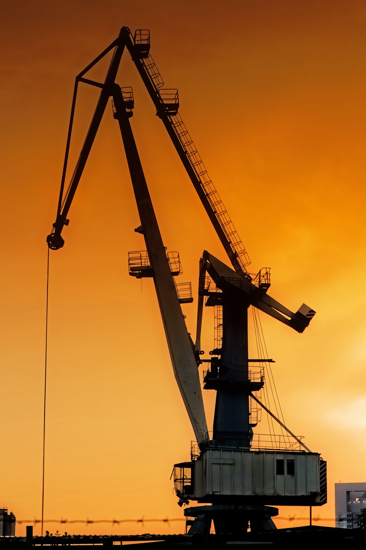 Silhouette of crane at sunrise, representing industrial crane services.