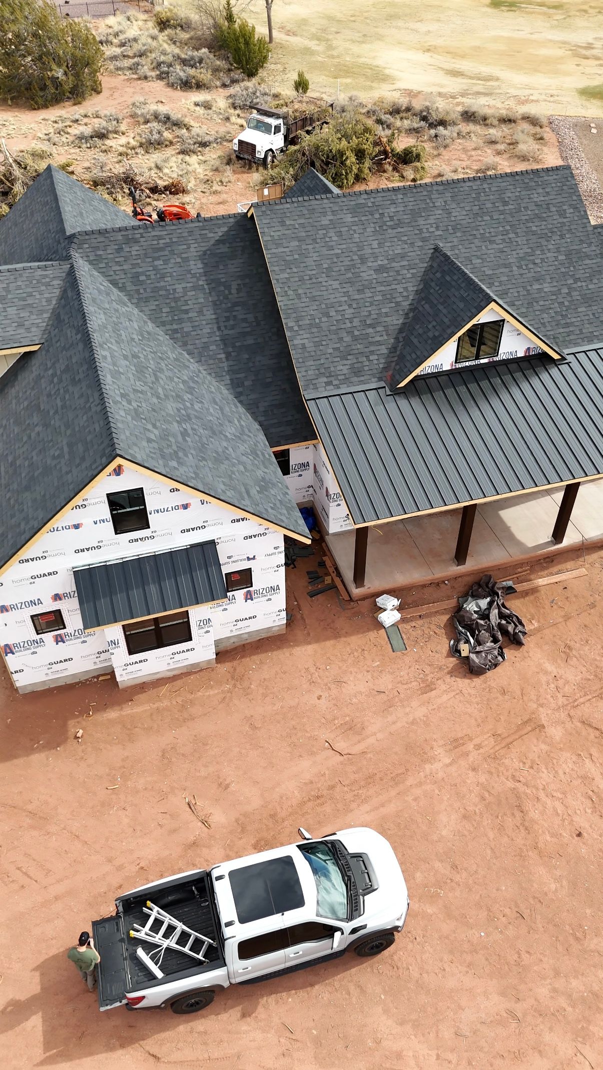 An aerial view of a house under construction with a truck parked in front of it.