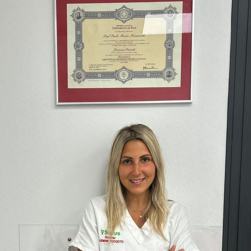 una donna è in piedi davanti a un certificato incorniciato