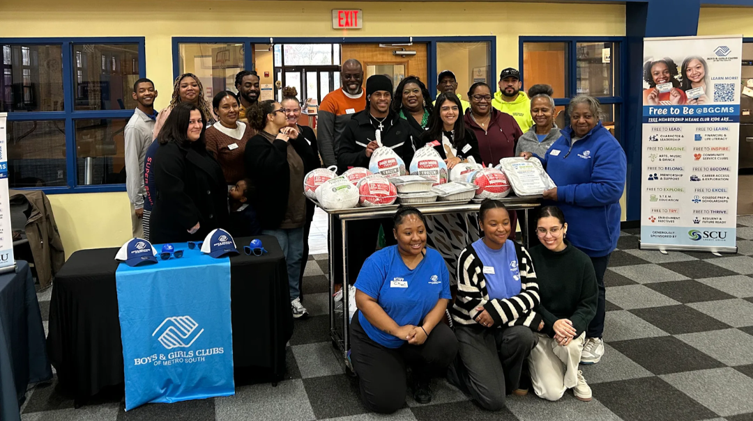 Boys & Girls Clubs of Metro South's Brockton Clubhouse Team poses with New England Patriots wide receiver DeMario Douglas during a visit donating Thanksgiving turkeys