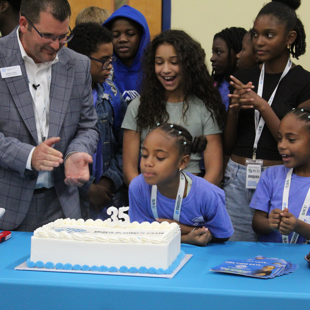 BGCMS Brockton Clubhouse member blows out candles surrounded by the CEO & President of BGCMS and other Club kids at the 35th anniversary of the Brockton Clubhouse.