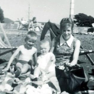 black and white photo of two children with their mother. 