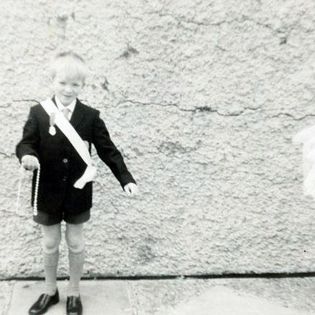 black and white photo of a young boy in a school uniform. 