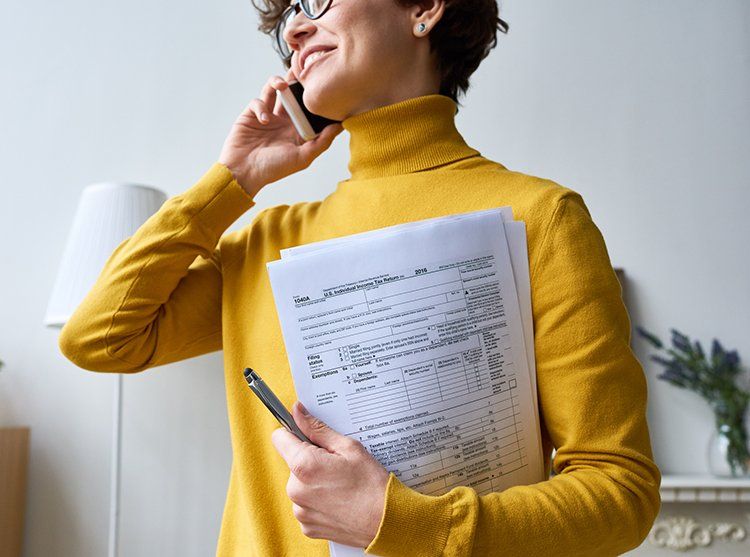 Woman Holding Papers — Madison, WI — EXACT Accounting & Financial Services