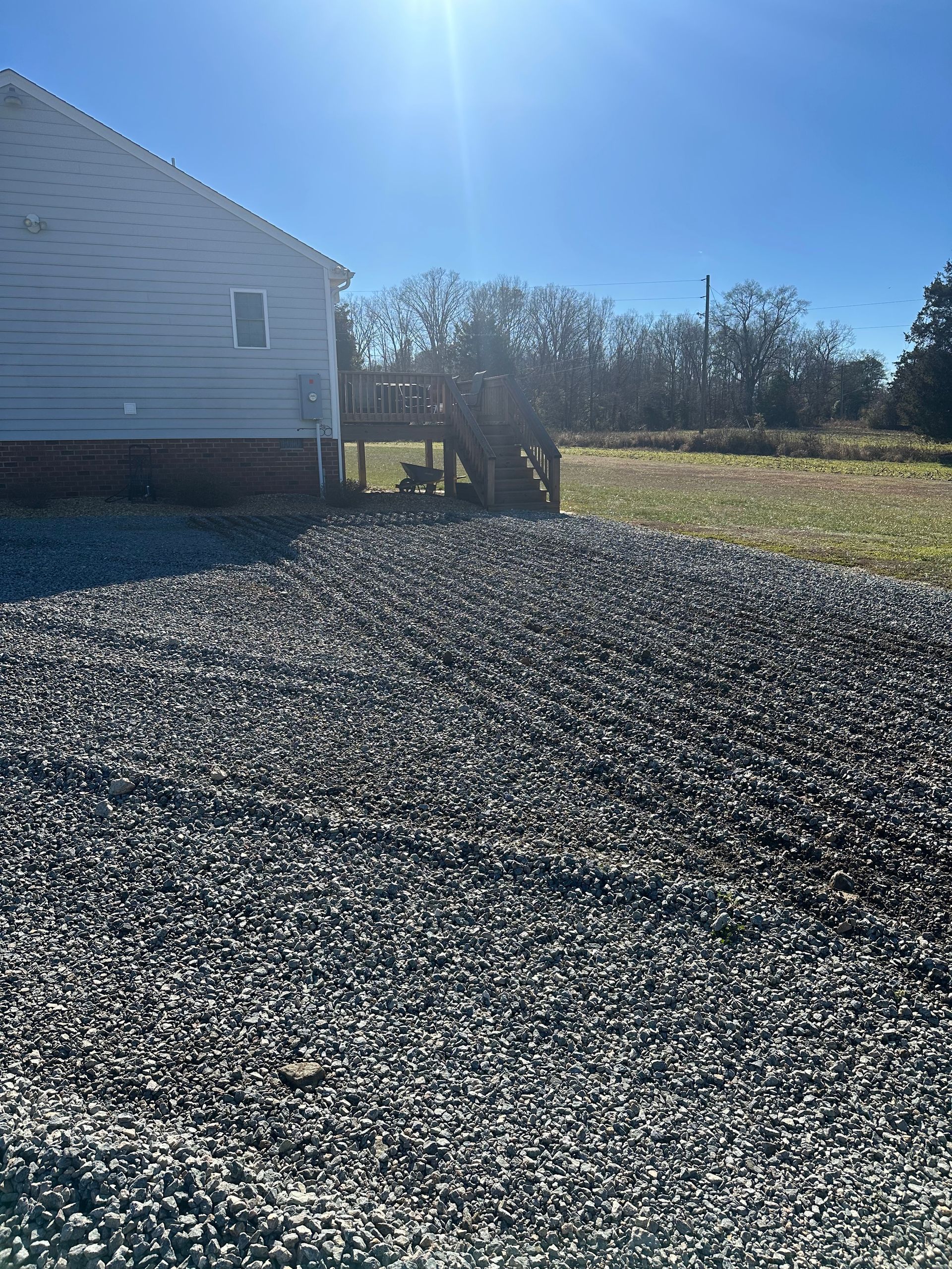 A pile of gravel is sitting in front of a house.