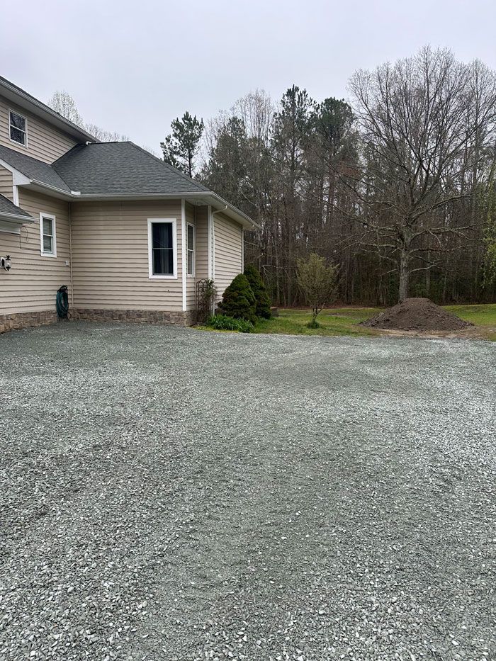 A house with a gravel driveway in front of it.
