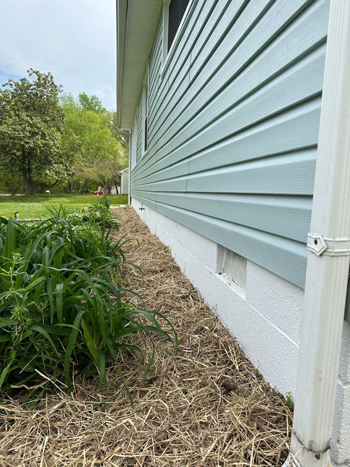A house with blue siding and a white gutter on the side of it.