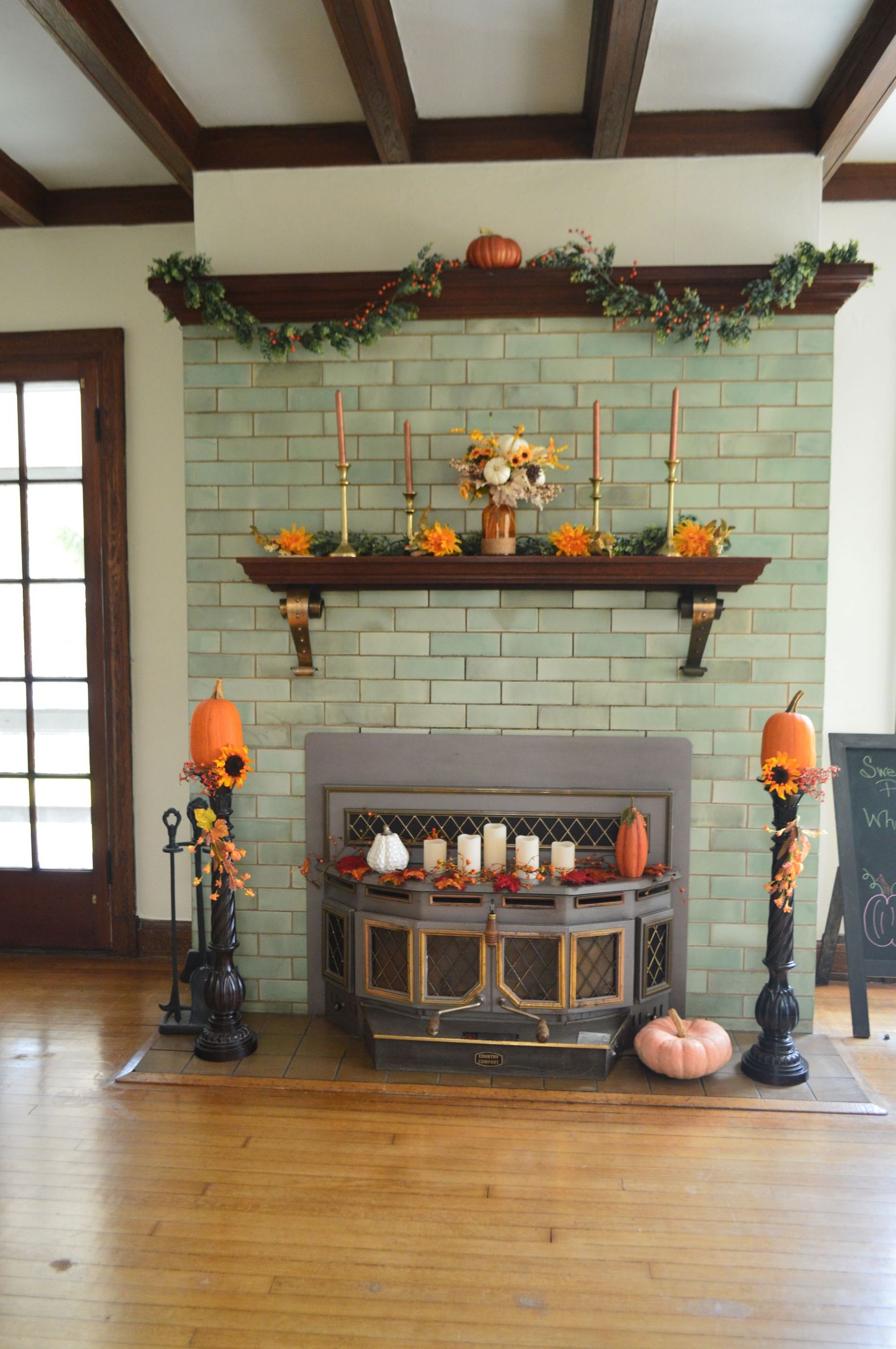 a fireplace decorated for fall with pumpkins and candles