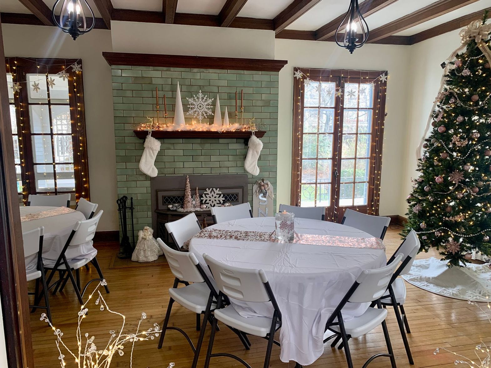 a room with tables and chairs and a christmas tree