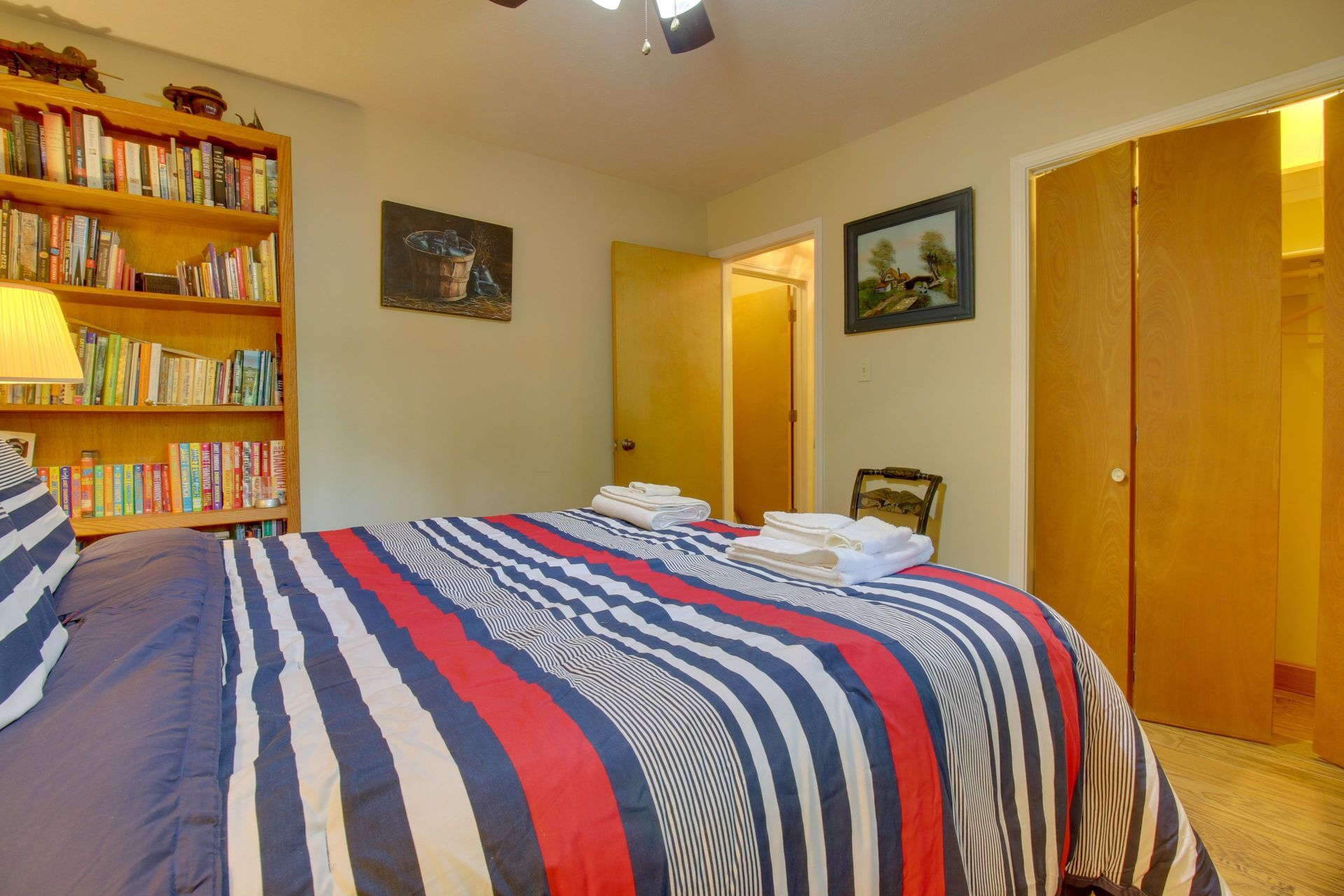 Bedroom with bed, bookcase, closet, and open doorway to a bathroom.