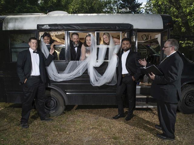 A group of people standing in front of a wedding bus