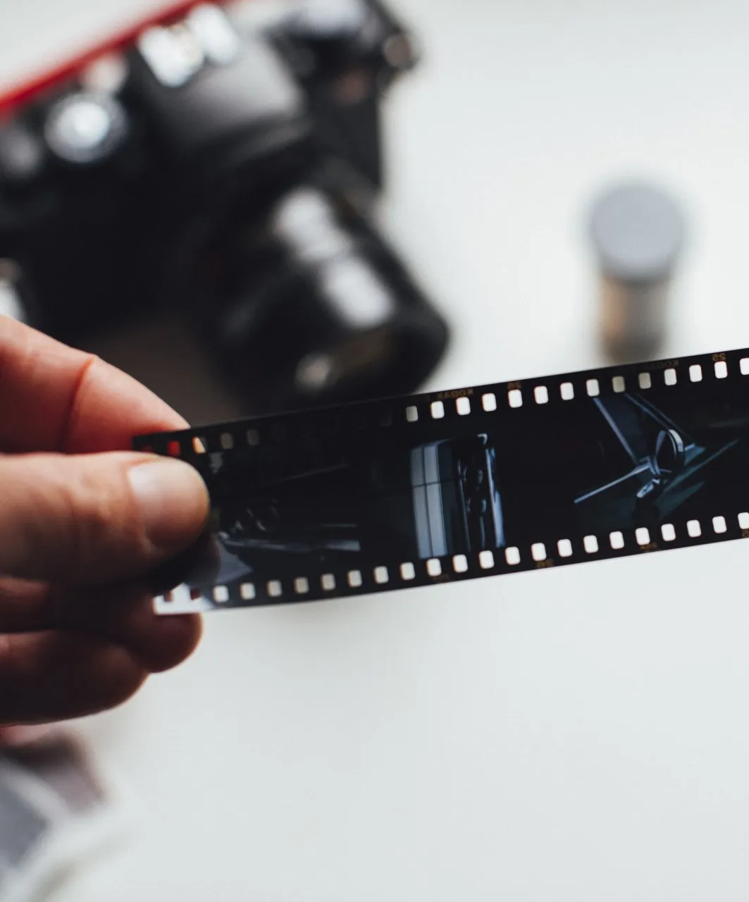 A person is holding a roll of film in their hand.