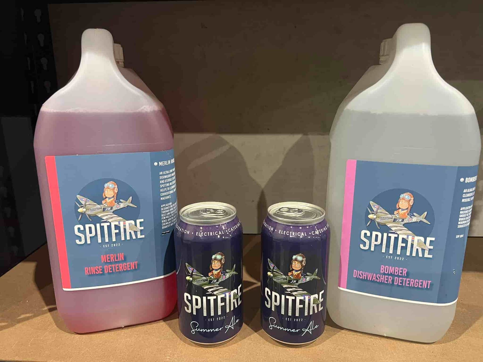 Two Bottles of Spitfire Next to Two Cans of Spitfire — Spitfire Chemicals Pty Ltd in Rutherford, NSW