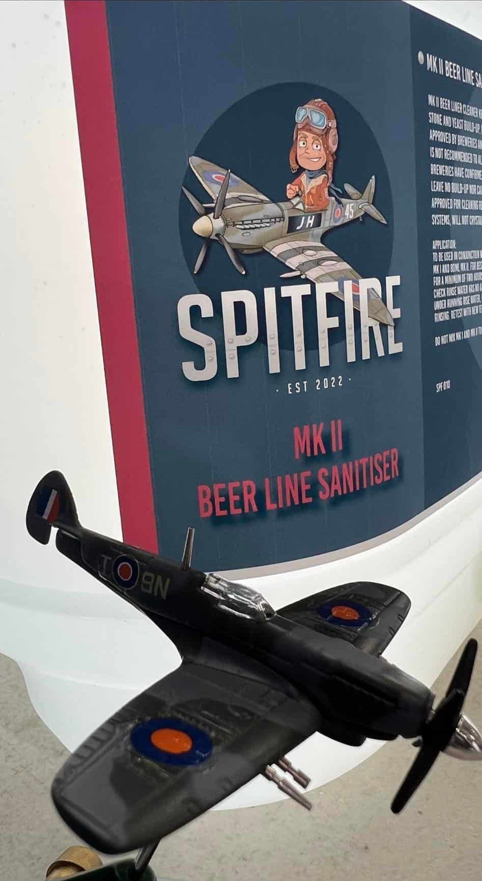A Model Airplane is Sitting in Front of a Sign That Says Spitfire — Spitfire Chemicals Pty Ltd in Rutherford, NSW