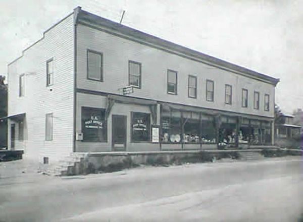 Two-story brick building with shop windows. 