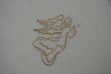 Embroidered golden angel with outstretched wings, blowing a horn, on a white background.