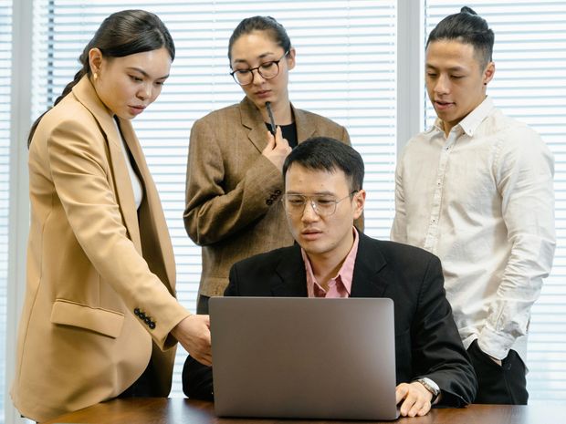 A group of people are looking at a laptop computer.