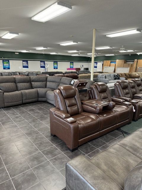 Furniture store interior with rows of couches and recliners on display.