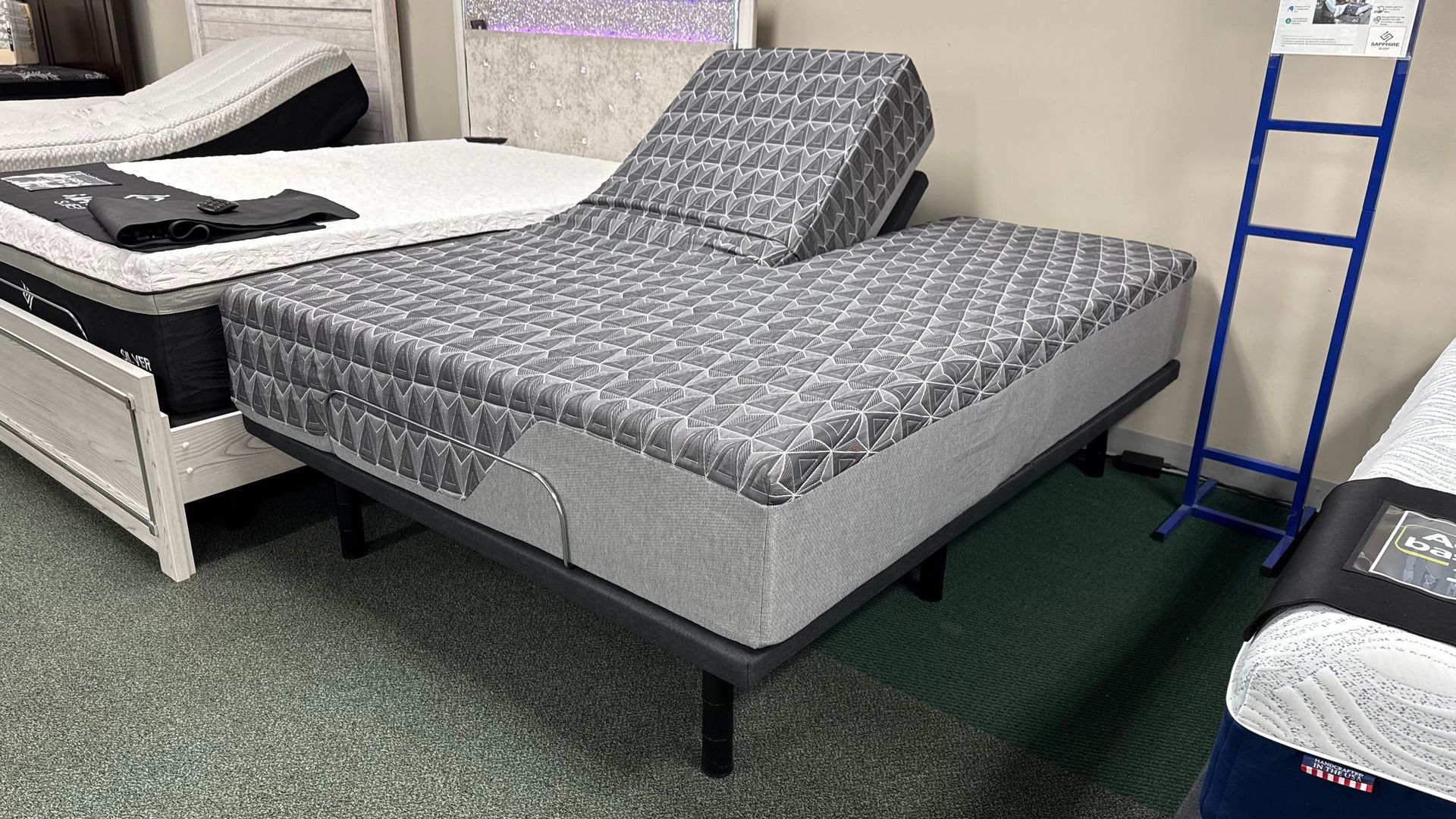 Queen-sized bed with a gray and white patterned mattress on a dark brown wooden frame in a room.