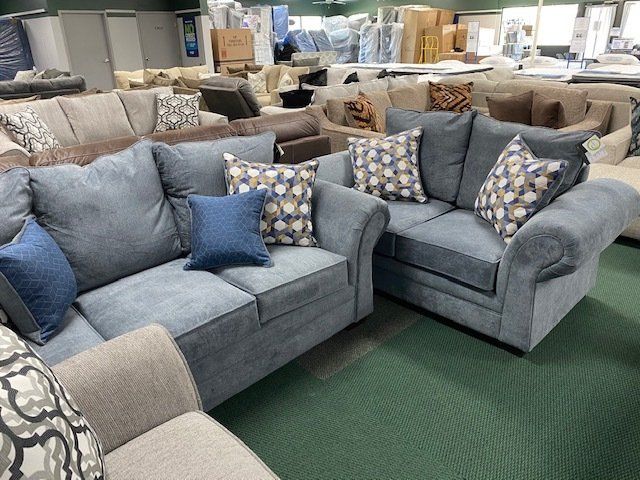Blue sofas with patterned pillows in a furniture store.