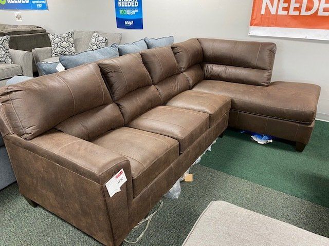 Brown leather sectional sofa in a furniture store.