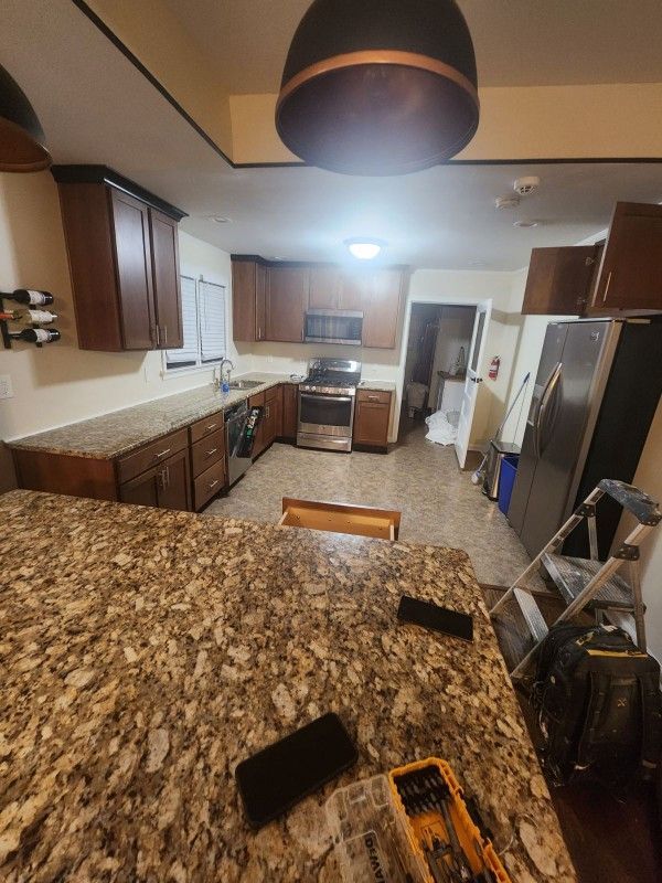 A kitchen with a granite counter top and stainless steel appliances.