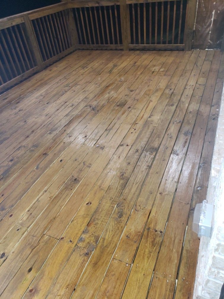 A wooden deck with a railing is being painted.