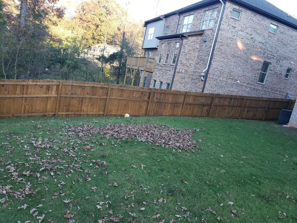There is a wooden fence in the backyard of a house.