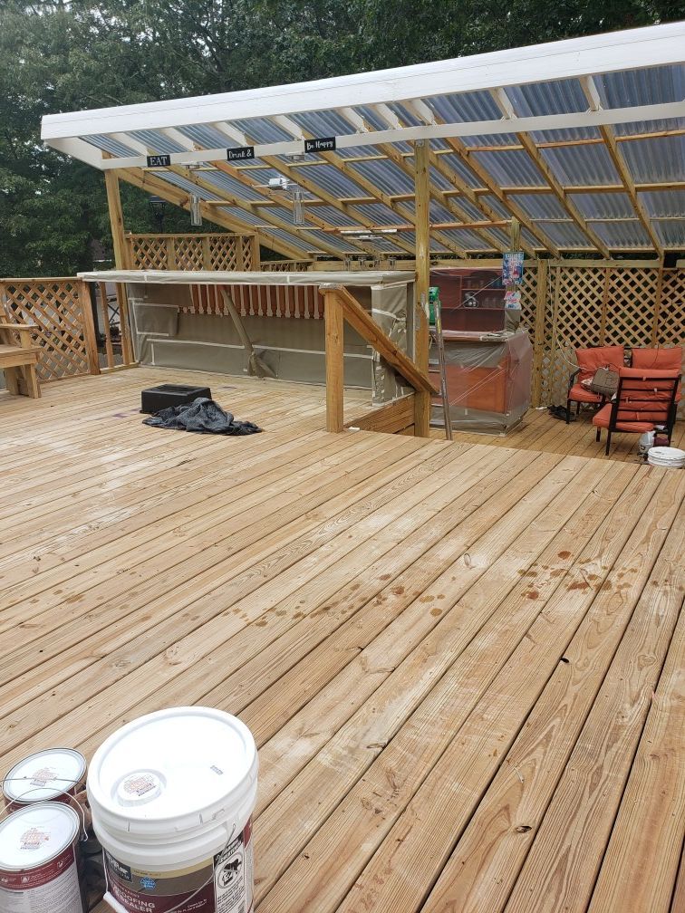 A wooden deck with buckets of paint on it.