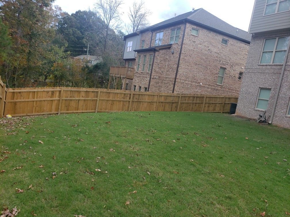 There is a wooden fence in the backyard of a house.