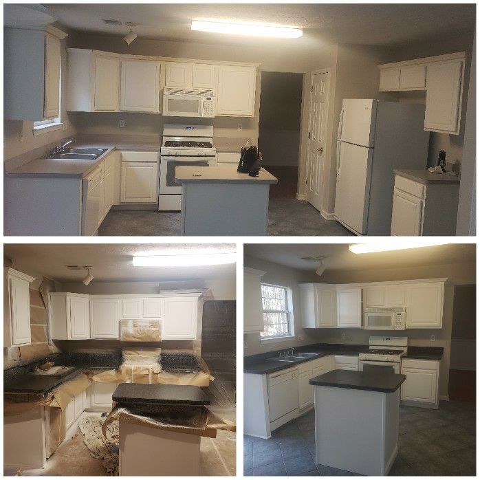 A kitchen with white cabinets and black counter tops