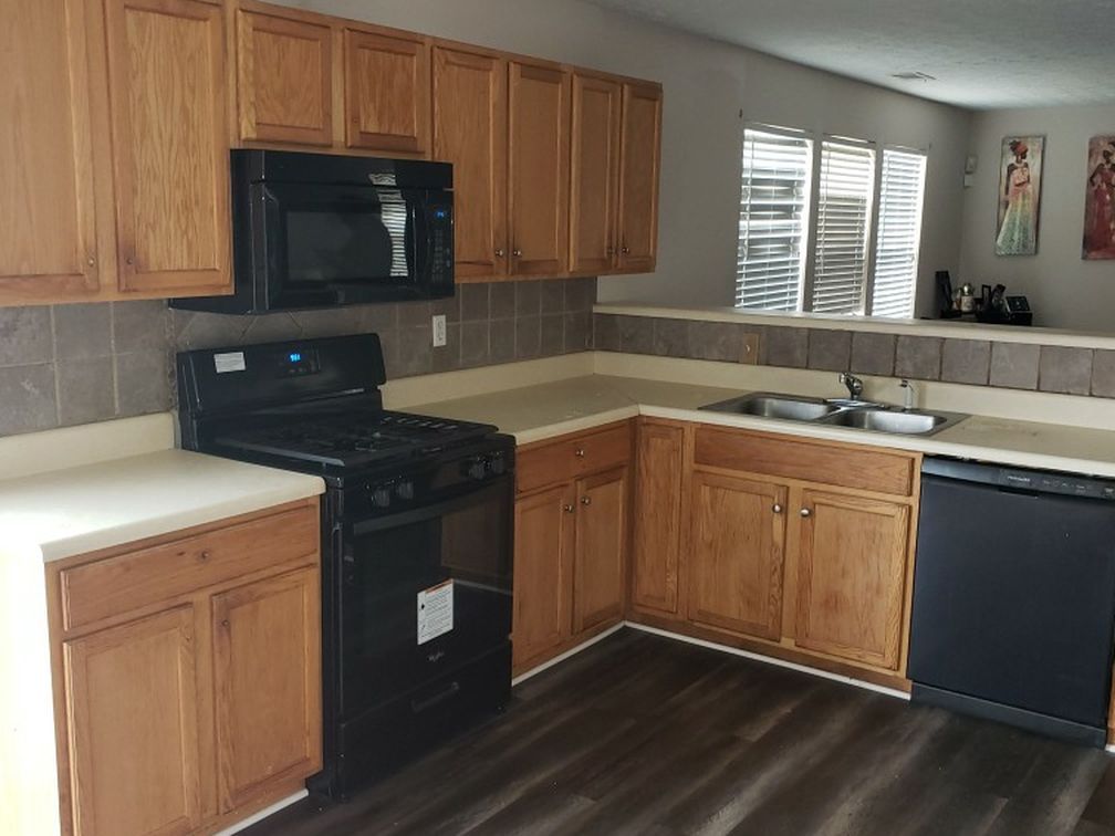 A kitchen with wooden cabinets and black appliances