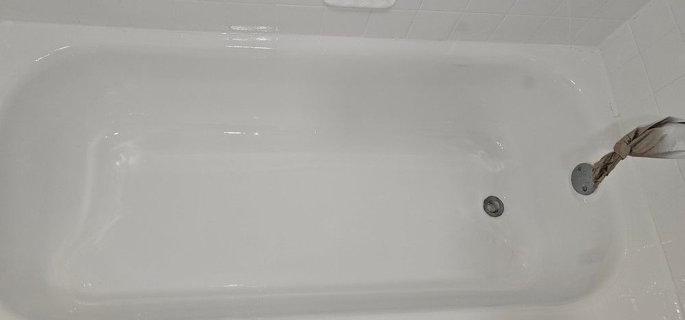 A white bathtub with a shower head in a bathroom.