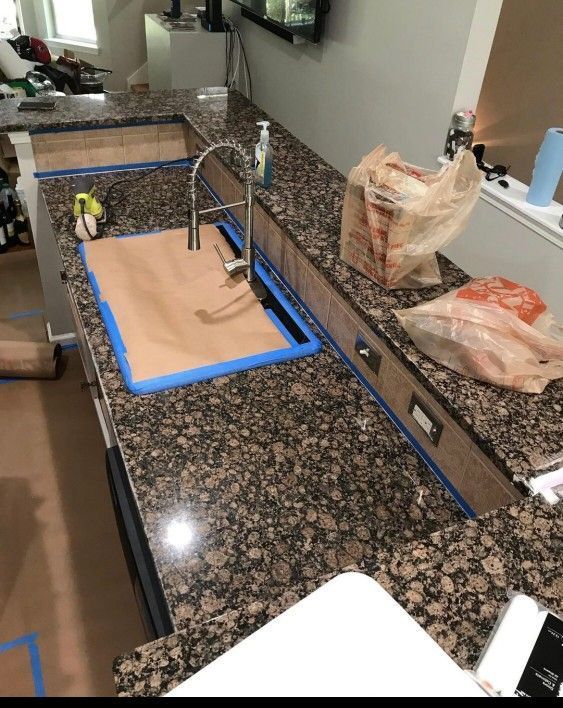 A kitchen counter with a sink and a bag of food