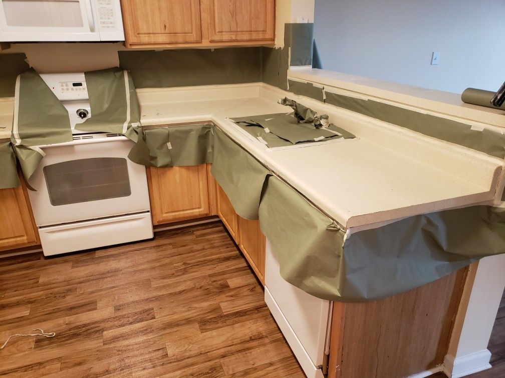 A kitchen with wooden cabinets , a stove , and a microwave.