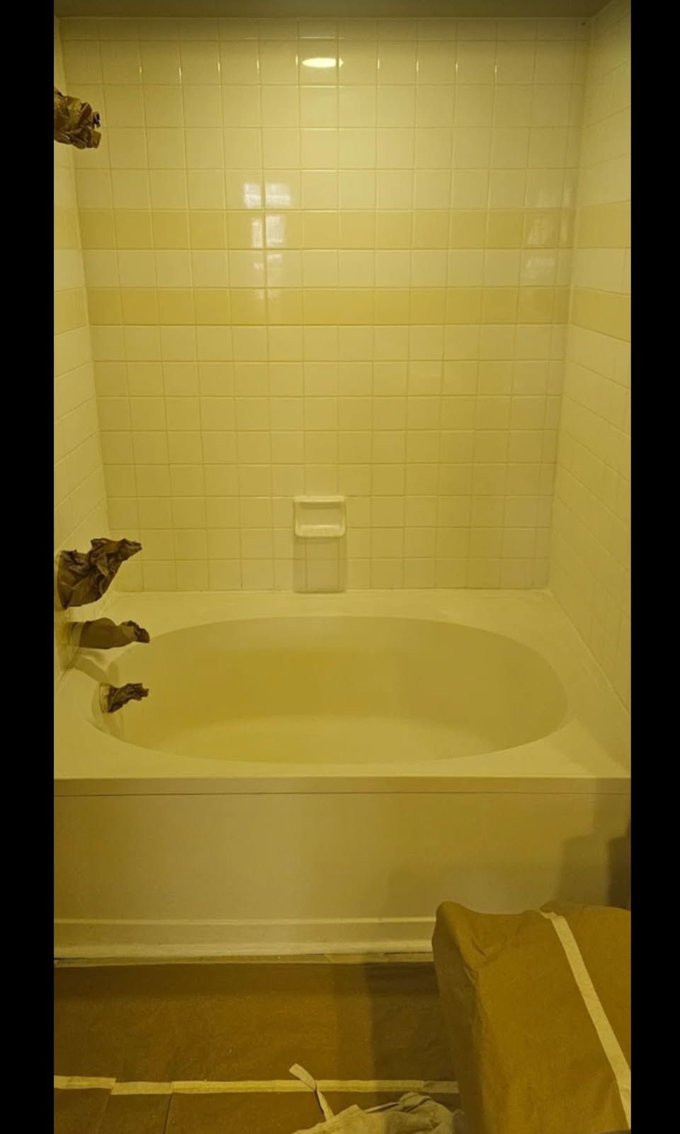A bathtub is sitting in a bathroom next to a box.